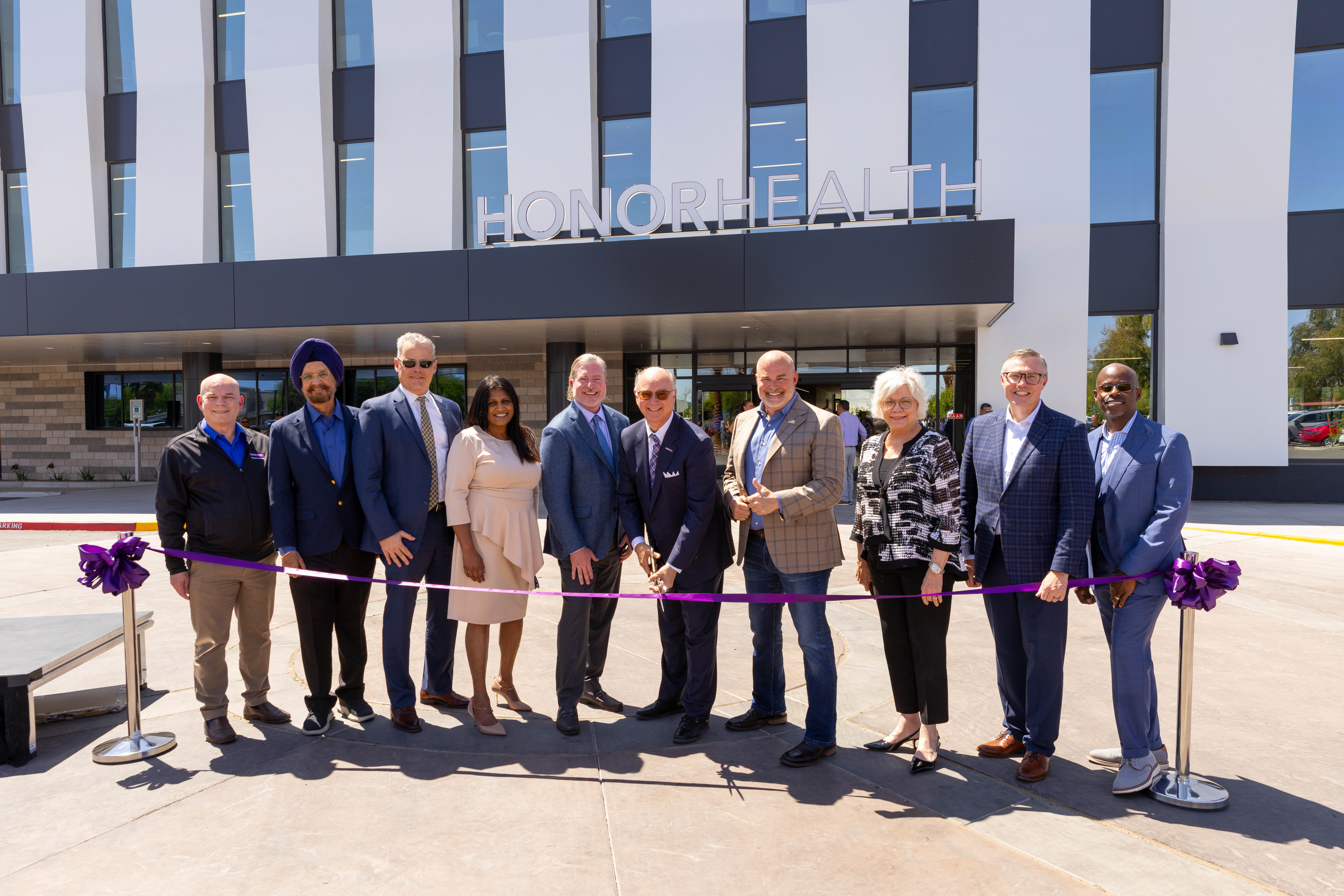 Group photo of HonorHealth leadership standing behind a ribbon at the ribbon cutting. 