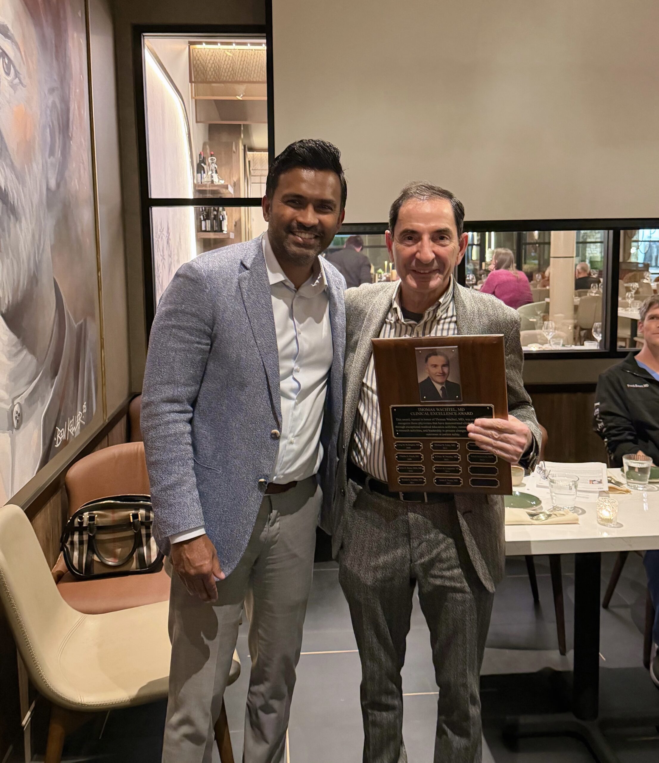 Dr. Kalamchi holding plaque posing with Dr. Itty. 