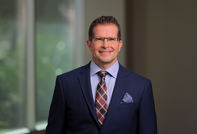 Headshot of John Pope, MD, in navy blue suit